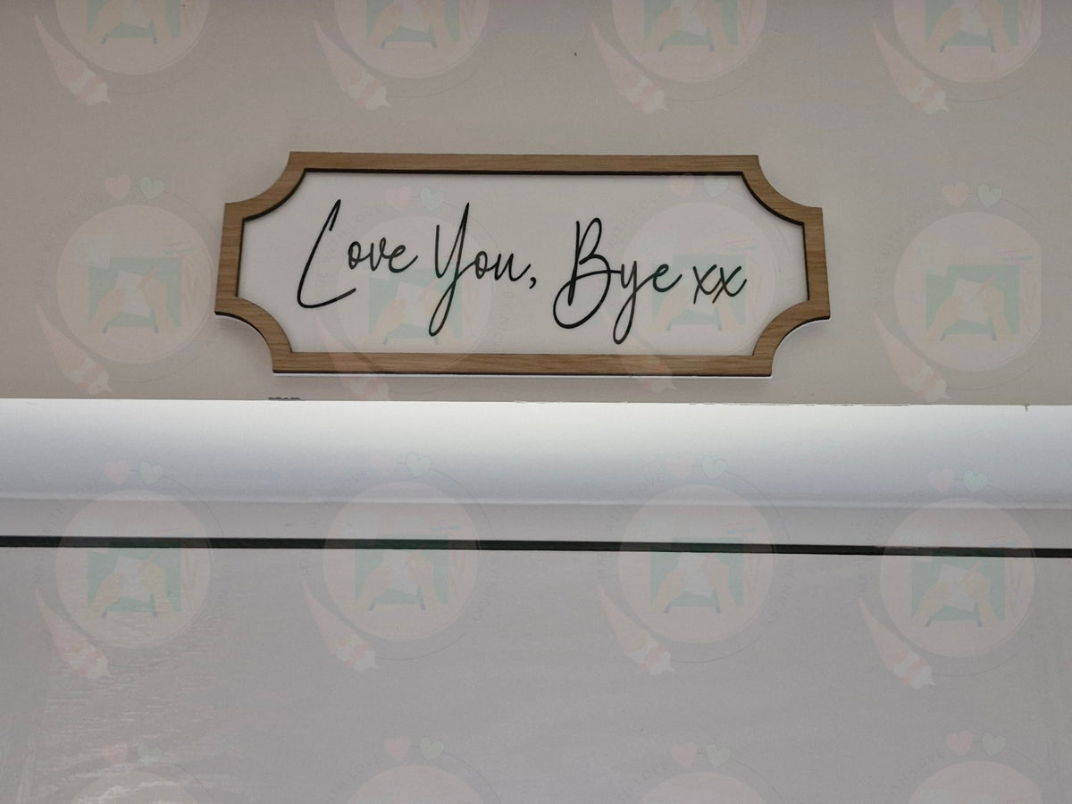 Love You, Bye sign displayed on wall in oak frame